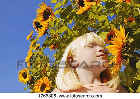 Girl stops to smell the flowers View Large Photo Image Stock Photography - Girl stops to smell the flowers. Fotosearch