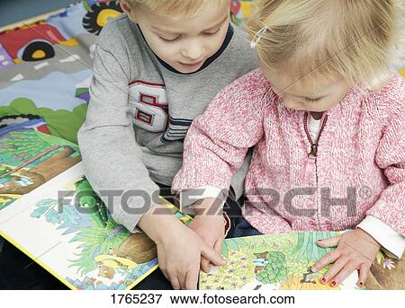Stock Photo - Two children read a book. Fotosearch
