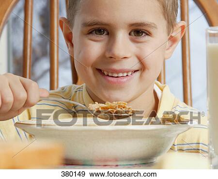 Young boy eating cereal at breakfast table View Large Photo Image Stock Photo - Young boy eating cereal at breakfast table. Fotosearch