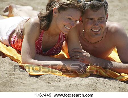 Couple laying on the beach View Large Photo Image Stock Photo - Couple laying on the beach. Fotosearch
