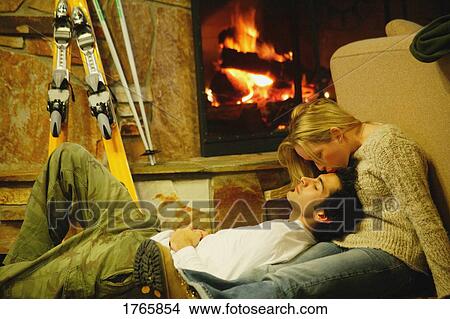 Stock Photo - Couple relax by fireplace. Fotosearch - Search Stock Images, Mural Photographs, Pictures, and Clipart Photos