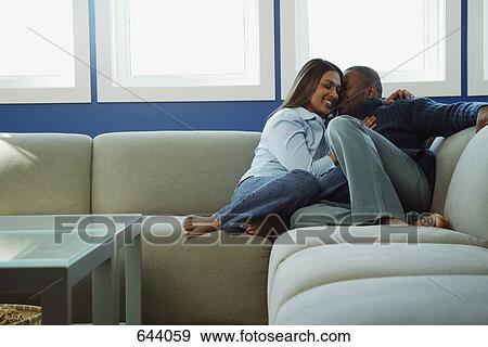 Couple snuggles on sofa View Large Photo Image Stock Photo - Couple snuggles on sofa. Fotosearch