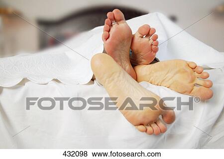 Couple snuggles under sheets View Large Photo Image Stock Photo - Couple snuggles under sheets. Fotosearch