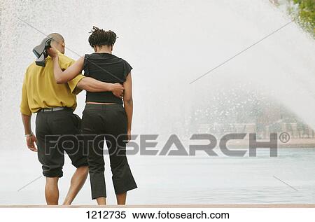 Stock Photography - Couple wading in a fountain. Fotosearch