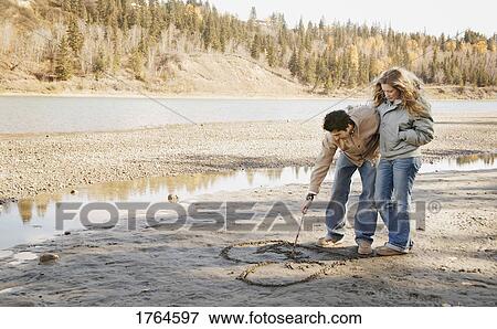 Stock Photo - Man writes in sand. Fotosearch