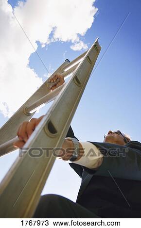 Stock Image - A businessman climbing the corporate ladder. Fotosearch