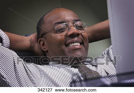 Businessman pleased in front of computer View Large Photo Image Stock Photo - Businessman pleased in front of computer. Fotosearch