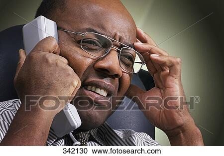 Stock Image - Businessman stress on phone. Fotosearch