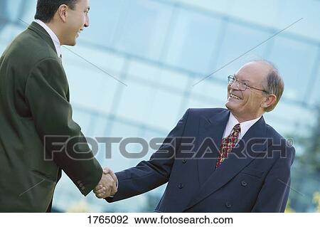 Stock Image - Businessmen shake hands. Fotosearch