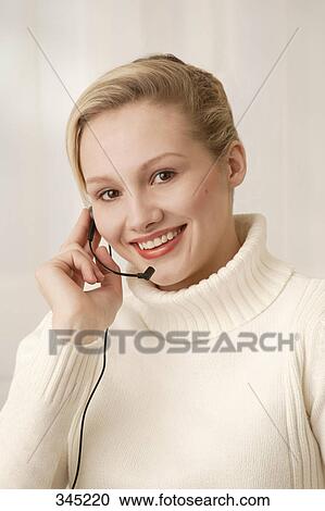 Stock Image - Woman wearing telephone headset. Fotosearch