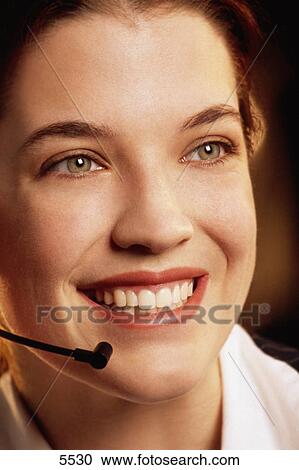 Stock Image - Woman wearing telephone headset. Fotosearch