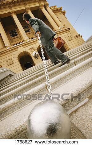 Businessman carrying a ball and chain View Large Photo Image Stock Photo - Businessman carrying a ball and chain. Fotosearch
