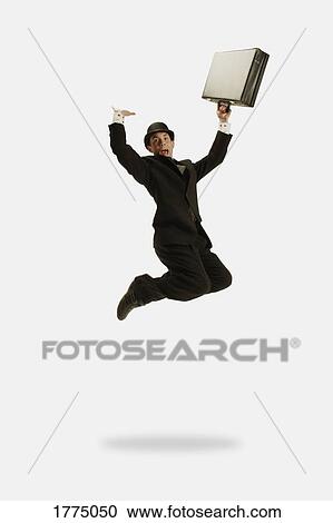 Stock Image - Businessman jumps with briefcase in hand. Fotosearch