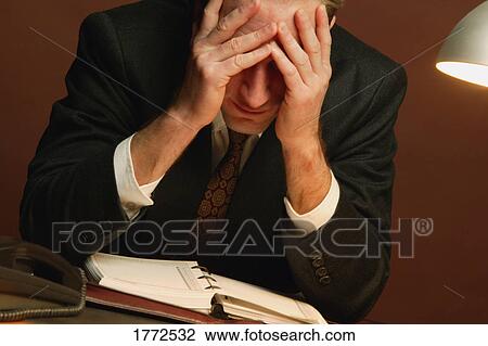 Stock Image - Businessman with head in hands. Fotosearch
