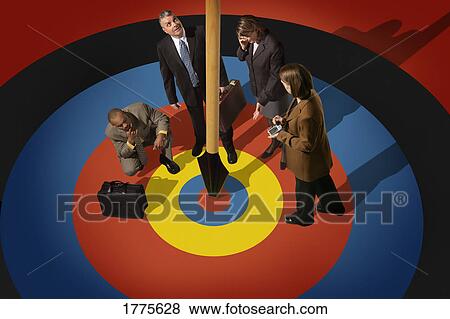 Businesspeople looking at dart in target View Large Photo Image Stock Photo - Businesspeople looking at dart in target. Fotosearch