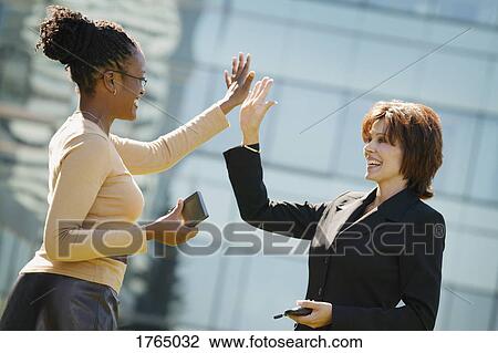 Stock Image - Businesswomen high five. Fotosearch
