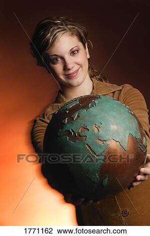 Stock Image - Globe held by woman. Fotosearch