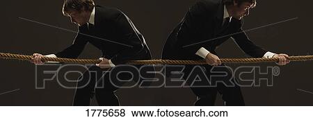 Two men pulling in opposite directions on a rope View Large Photo Image Stock Photo - Two men pulling in opposite directions on a rope. Fotosearch