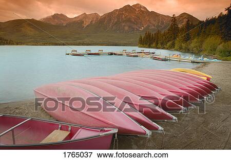A row of canoes in the mountains View Large Photo Image Stock Photo - A row of canoes in the mountains. Fotosearch