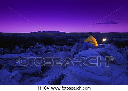Picture - Hiker watching the sky in twilight. Fotosearch