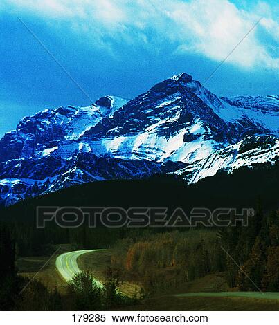 Snow-covered mountain with road in foreground View Large Photo Image Stock Photography - Snow-covered mountain with road in foreground. Fotosearch