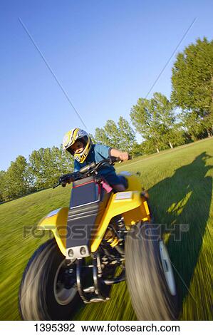 Stock Image - Child rides a quad. Fotosearch