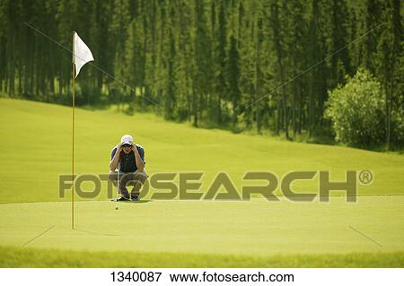 Stock Photo - Lining up for the putt. Fotosearch