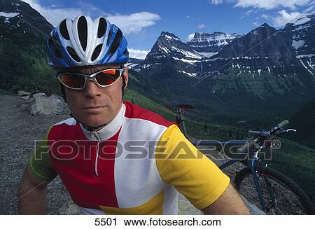 Stock Image - Mountain biker with mountainous backdrop. Fotosearch