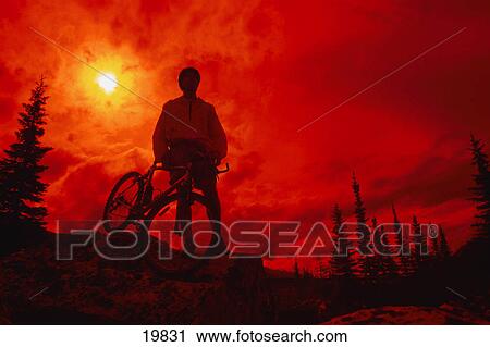 Sun behind cyclist on hill View Large Photo Image Stock Image - Sun behind cyclist on hill. Fotosearch