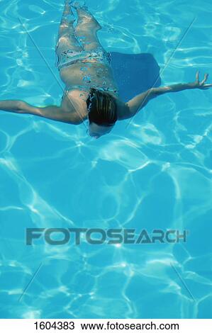 Stock Image - Woman swims under water. Fotosearch