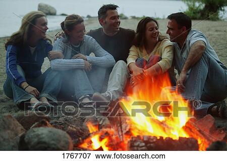 Stock Photo - A group of people enjoy a bonfire. Fotosearch