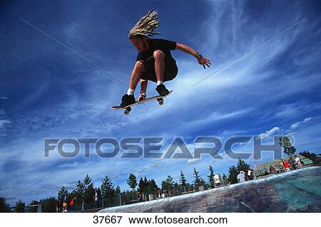 Boarder performing stunt at skate park View Large Photo Image Stock Photo - Boarder performing stunt at skate park. Fotosearch