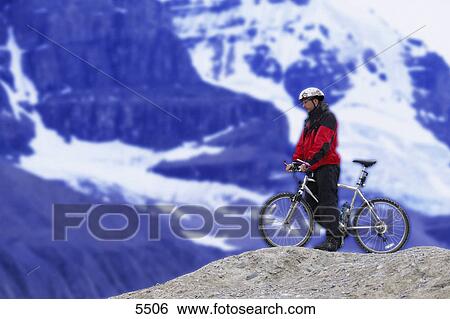 Cyclist atop hill enjoying the view View Large Photo Image Stock Photograph - Cyclist atop hill enjoying the view. Fotosearch