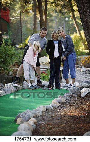 Family plays mini golf View Large Photo Image Stock Image - Family plays mini golf. Fotosearch