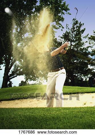 Golfer chips out of the sand trap View Large Photo Image Stock Photograph - Golfer chips out of the sand trap. Fotosearch