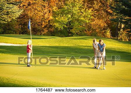 Mother teaches daughter to putt View Large Photo Image Stock Photo - Mother teaches daughter to putt. Fotosearch
