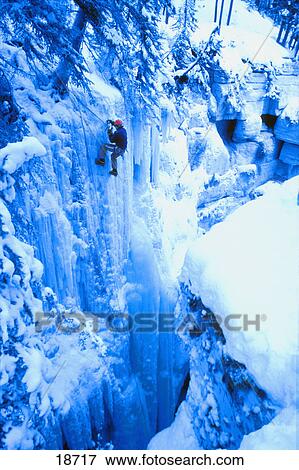 Stock Photo - Person scaling ice cliff. Fotosearch