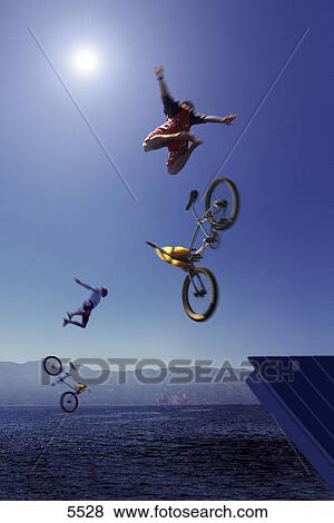 Two cyclists jumping into water from a ramp View Large Photo Image Stock Photo - Two cyclists jumping into water from a ramp. Fotosearch