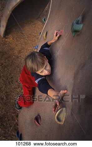 Stock Photo - Young boy ascending climbing wall. Fotosearch