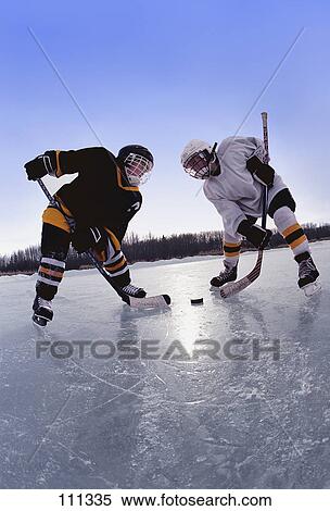 Young boys playing ice hockey outdoors View Large Photo Image Stock Photography - Young boys playing ice hockey outdoors. Fotosearch