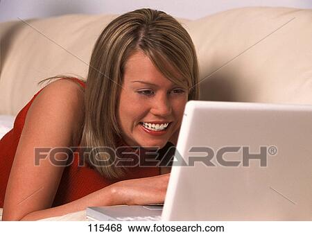 Girl laying on sofa with laptop computer View Large Photo Image Stock Photo - Girl laying on sofa with laptop computer. Fotosearch