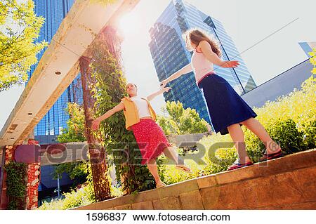 Stock Photo - Two teenagers dance on a ledge. Fotosearch