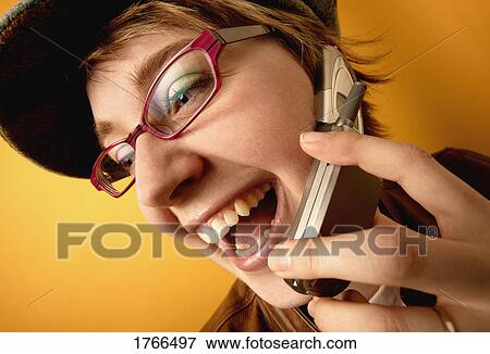 Stock Photo - Woman talks on cell phone. Fotosearch