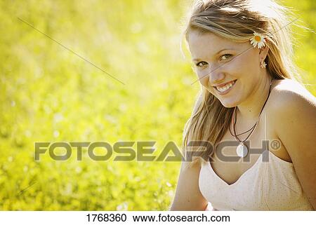 Young woman sitting on the grass View Large Photo Image Stock Image - Young woman sitting on the grass. Fotosearch