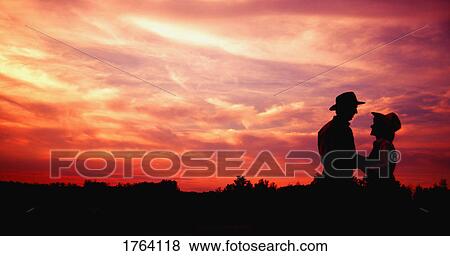 Couple embrace at sunset View Large Photo Image Stock Photo - Couple embrace at sunset. Fotosearch