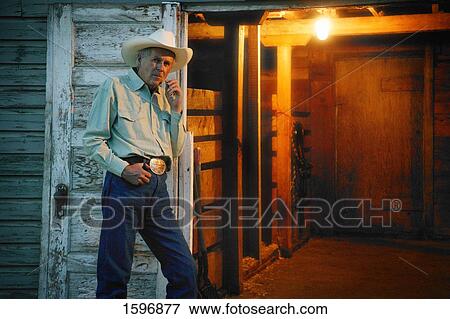 Stock Photo - Cowboy stands by door. Fotosearch