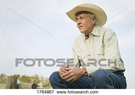 Stock Photo - Man looks out over his ranch. Fotosearch
