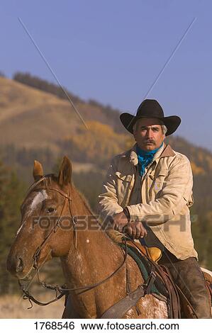 Stock Photograph - Portrait of cowboy on horse. Fotosearch