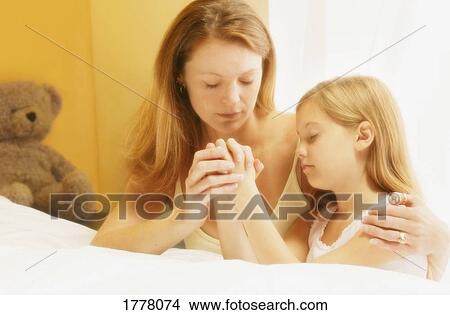 Mother praying with daughter View Large Photo Image Picture - Mother praying with daughter. Fotosearch