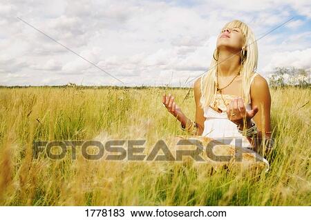 Portrait of woman praying in field View Large Photo Image Stock Image - Portrait of woman praying in field. Fotosearch